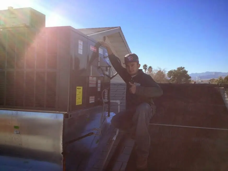 HVAC technician performing Boiler Repair on a rooftop unit in Holiday